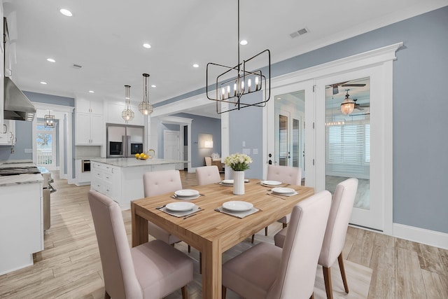 dining space featuring light wood-type flooring, visible vents, and a notable chandelier