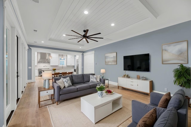 living room with baseboards, a tray ceiling, recessed lighting, light wood-style floors, and wooden ceiling