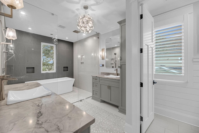 full bathroom featuring vanity, visible vents, a freestanding bath, tile patterned flooring, and a chandelier