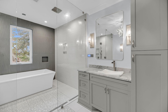 bathroom featuring visible vents, a walk in shower, a freestanding bath, tile patterned floors, and vanity