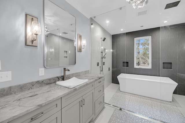 bathroom with visible vents, recessed lighting, a shower stall, a freestanding bath, and vanity