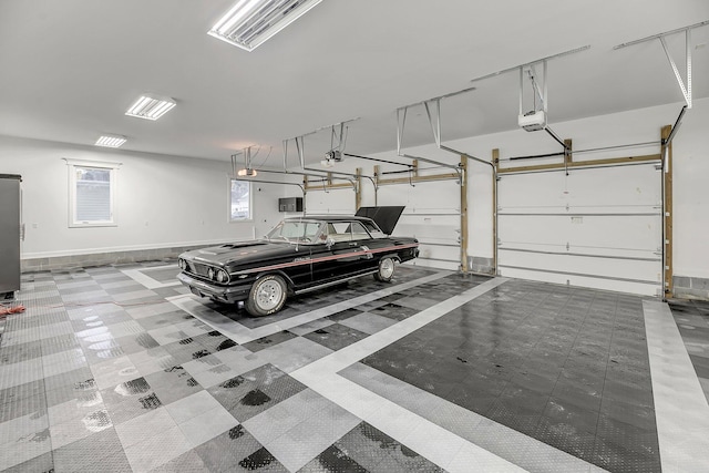 garage with baseboards and a garage door opener