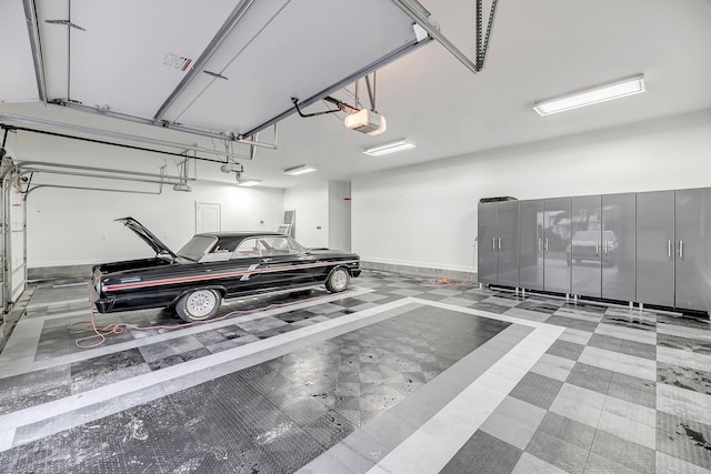 garage featuring a garage door opener and baseboards