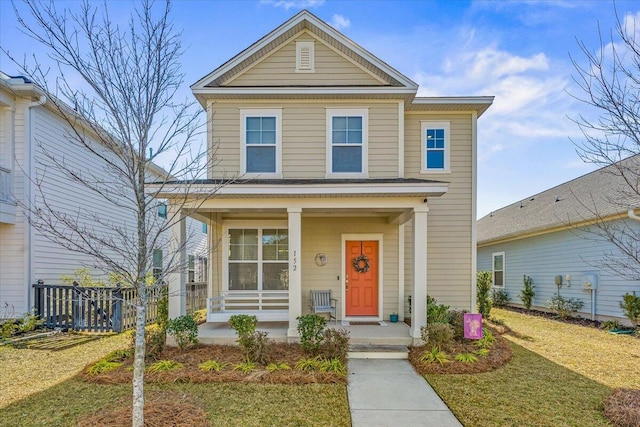 front facade featuring covered porch and a front lawn