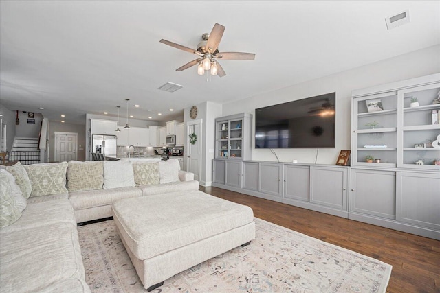 living room featuring sink, light wood-type flooring, and ceiling fan