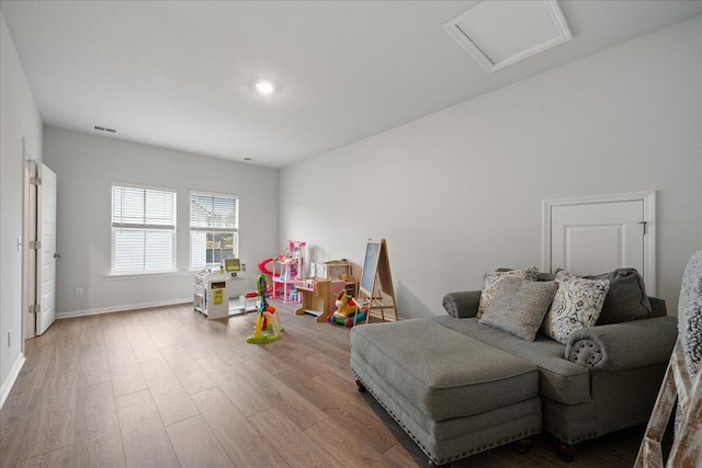 game room with baseboards, attic access, visible vents, and wood finished floors