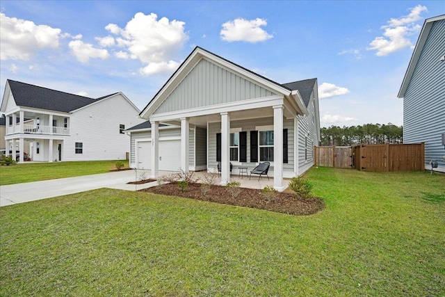 view of front facade with covered porch, concrete driveway, a front lawn, and board and batten siding