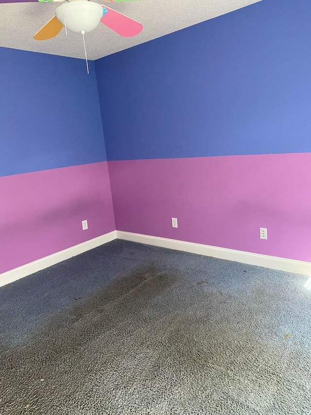 carpeted empty room featuring ceiling fan and a textured ceiling