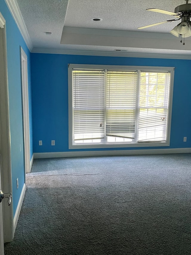 carpeted empty room with ceiling fan, a textured ceiling, and crown molding