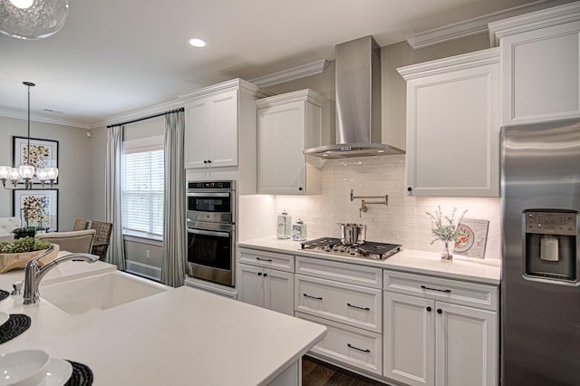 kitchen with stainless steel appliances, white cabinetry, wall chimney exhaust hood, and crown molding