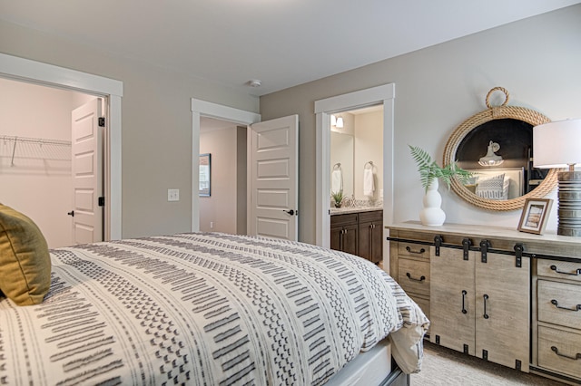 carpeted bedroom featuring a closet, ensuite bath, and a spacious closet