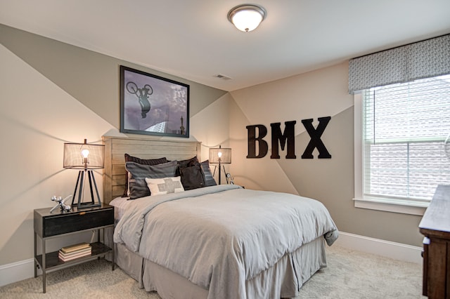 bedroom with light carpet and multiple windows