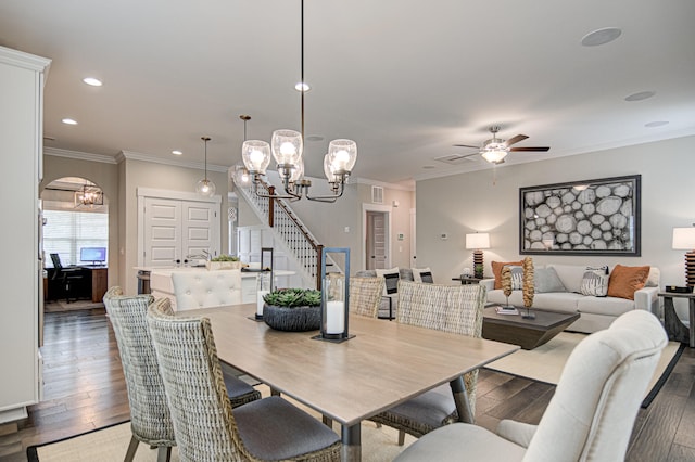 dining space with crown molding, dark wood-type flooring, and ceiling fan with notable chandelier