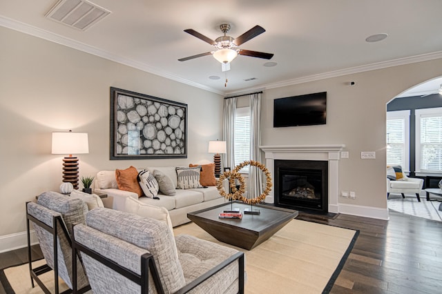 living room featuring dark hardwood / wood-style floors, ceiling fan, and ornamental molding