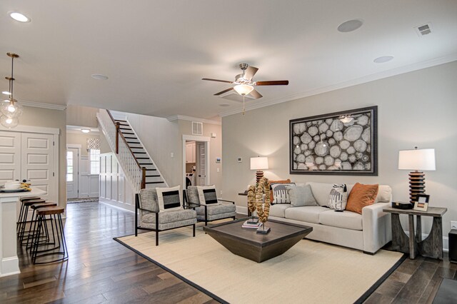 living room featuring hardwood / wood-style floors, ceiling fan, and crown molding