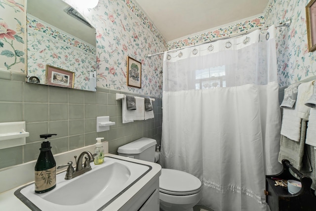 bathroom with a shower with curtain, tile walls, and toilet