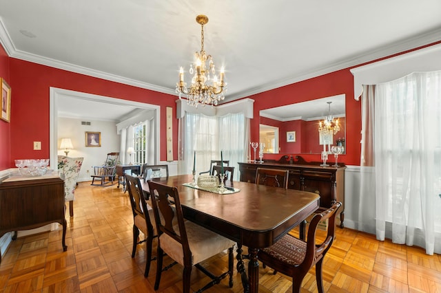 dining room with an inviting chandelier, crown molding, and light parquet flooring