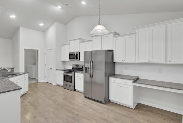 kitchen with white cabinetry, pendant lighting, dark stone counters, and appliances with stainless steel finishes