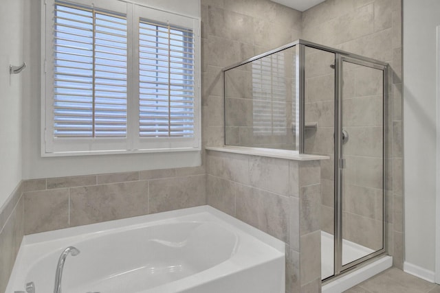 bathroom featuring tile patterned floors, separate shower and tub, and a wealth of natural light