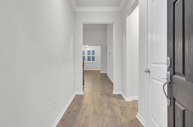 hallway with light hardwood / wood-style flooring and a chandelier