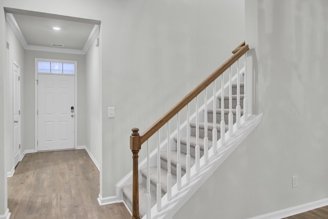 entrance foyer featuring hardwood / wood-style floors and crown molding