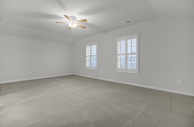 empty room featuring ceiling fan, carpet flooring, and vaulted ceiling