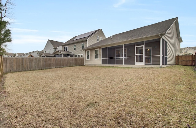 back of property featuring a yard and a sunroom