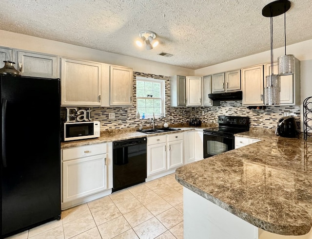 kitchen featuring black appliances, kitchen peninsula, light tile patterned floors, sink, and decorative light fixtures