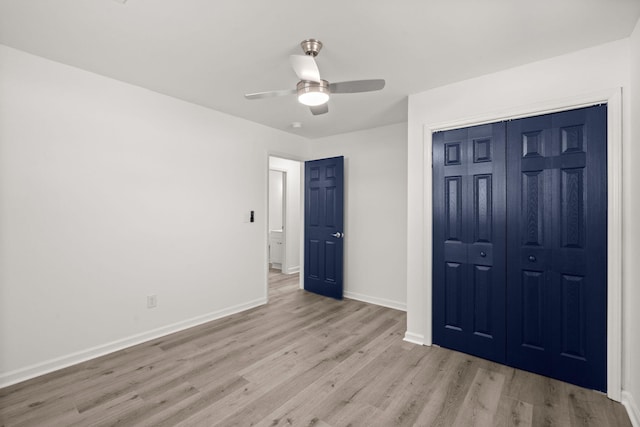 unfurnished bedroom with ceiling fan, light hardwood / wood-style flooring, and a closet