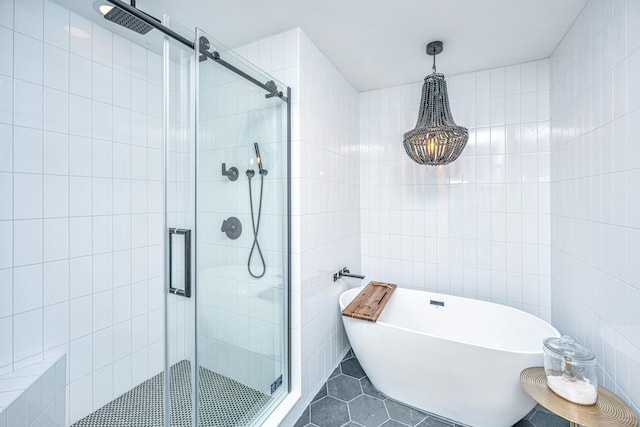 bathroom with tile patterned flooring, a freestanding bath, tile walls, and a shower stall