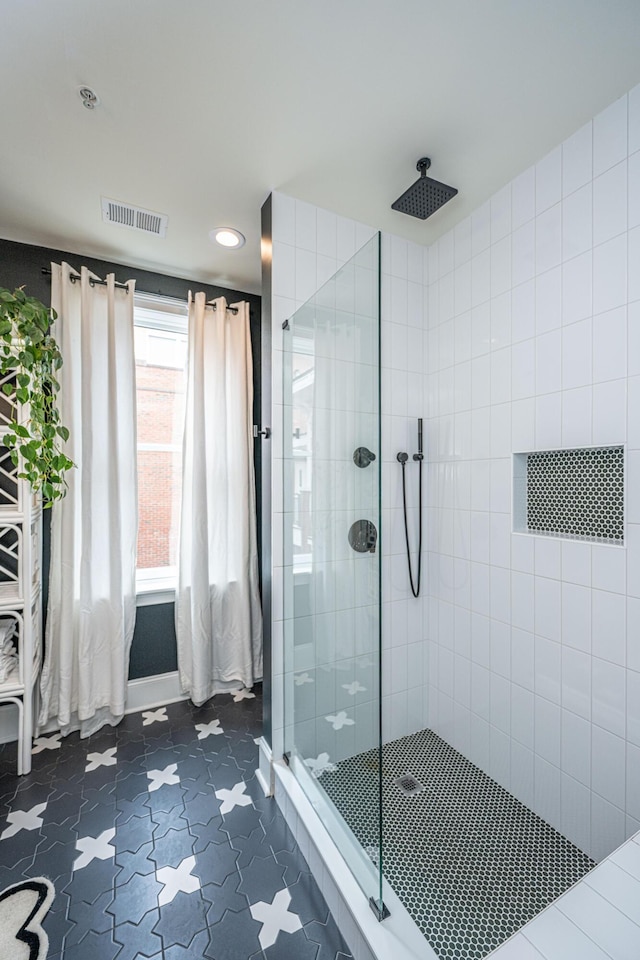 full bath with visible vents and tiled shower