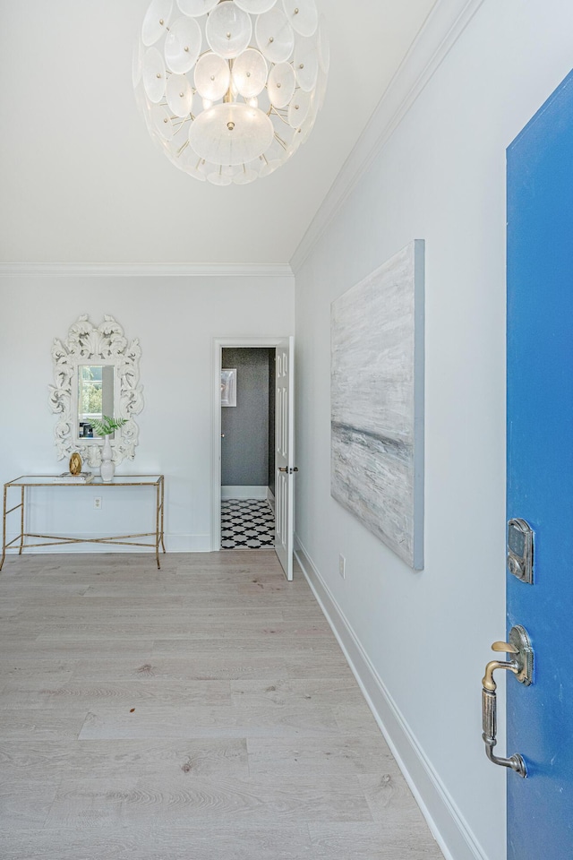 hallway featuring light wood finished floors, baseboards, and crown molding