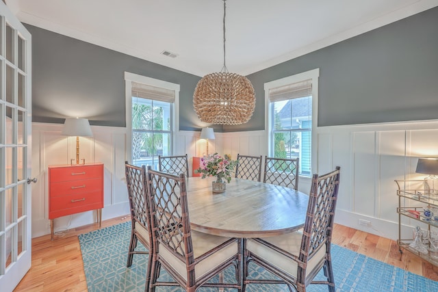 dining room featuring crown molding, plenty of natural light, and light hardwood / wood-style flooring