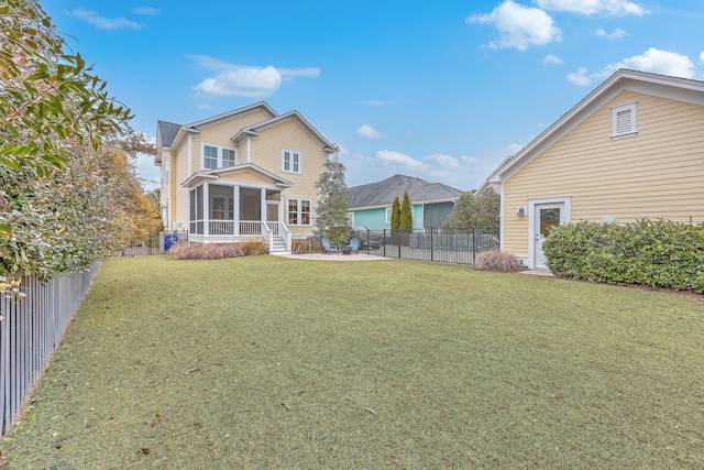 back of property featuring a yard, a patio area, and a sunroom