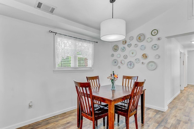 dining room with baseboards, light wood-style flooring, and visible vents