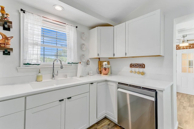 kitchen featuring light wood finished floors, light countertops, dishwasher, a sink, and white cabinetry