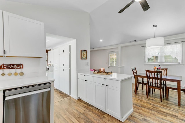 kitchen with stainless steel dishwasher, vaulted ceiling, visible vents, and light countertops