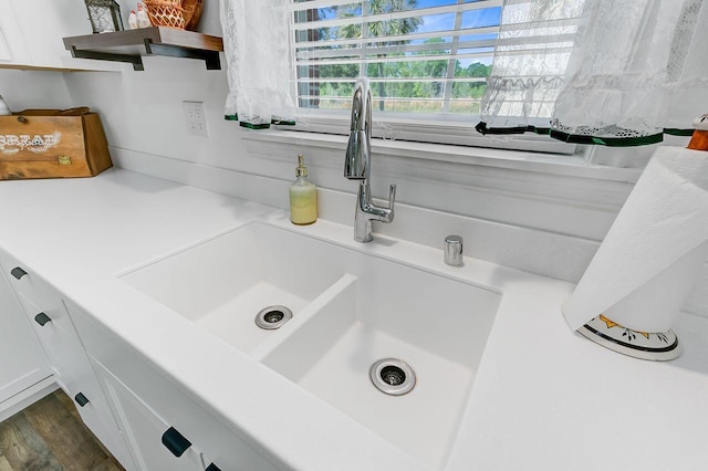 room details with white cabinetry, open shelves, a sink, and light countertops