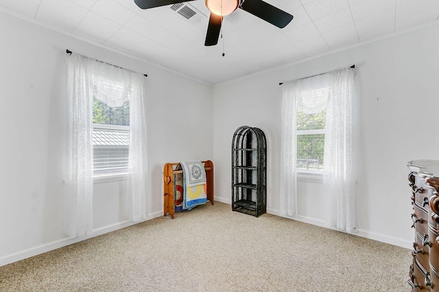 interior space featuring carpet floors, visible vents, ceiling fan, and ornamental molding
