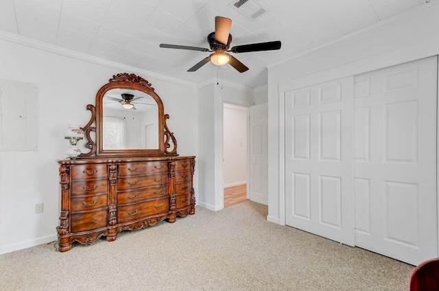 carpeted bedroom featuring electric panel, baseboards, visible vents, a closet, and crown molding