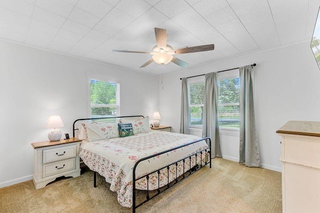 bedroom with baseboards, a ceiling fan, and light colored carpet