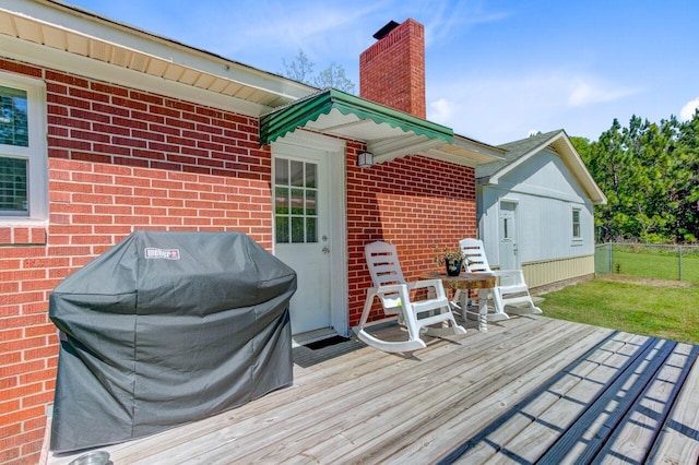 deck with a yard, fence, and a grill