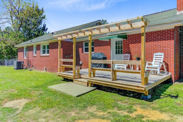 rear view of house featuring a wooden deck, brick siding, a yard, and central AC unit