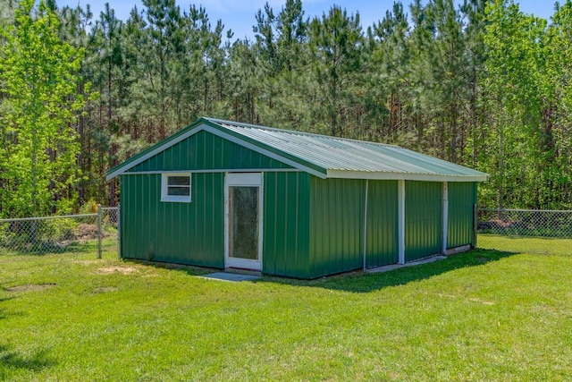 view of outdoor structure featuring a fenced backyard, an outdoor structure, and a wooded view
