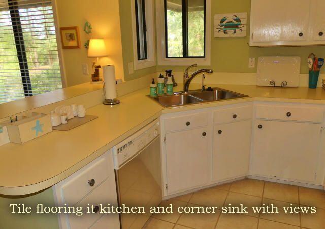 kitchen featuring white cabinets, white dishwasher, light countertops, and a sink