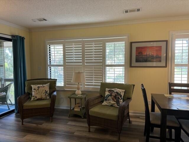 sitting room featuring crown molding, visible vents, and dark wood-style flooring