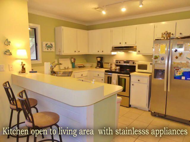 kitchen with stainless steel appliances, light countertops, white cabinets, and a peninsula