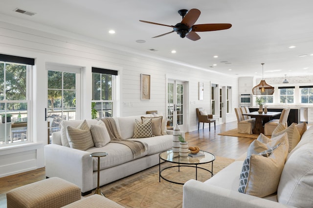 living room with light hardwood / wood-style floors and ceiling fan