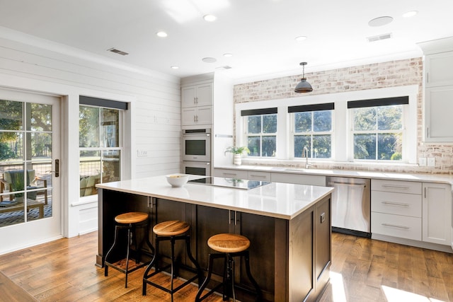 kitchen featuring appliances with stainless steel finishes, a healthy amount of sunlight, and a kitchen island