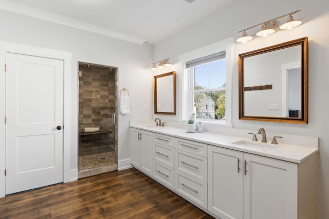 bathroom with hardwood / wood-style flooring, vanity, and a shower with shower door